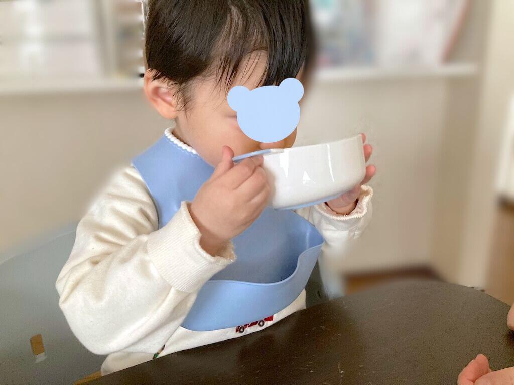 モグモの「カラダにやさしいほっこりコーンポタージュ」を飲む2歳の子ども